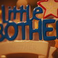 Load image into Gallery viewer, Decorative item with blue letters spelling 'little brother' on a beige background.