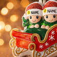 Load image into Gallery viewer, Personalized couple ornament featuring two characters sitting together in a festive sleigh design. This romantic Christmas ornament can be customized with two names and a year or family name, making it perfect for couples, partners, spouses, fiancés, or loved ones. Ideal for celebrating love, togetherness, Valentine’s Day, anniversaries, or first holidays together. A meaningful keepsake for couples who want to turn shared moments into lasting holiday memories.