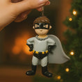 Load image into Gallery viewer, Personalized superhero boy Christmas ornament featuring a mask, cape and custom name. Cute holiday decor for boys, perfect for Christmas trees and gift-giving. Add name and year to create a unique keepsake. Display photos are AI-generated; please check the first image for the original product.