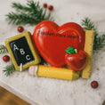 Load image into Gallery viewer, Decorative ornament shaped like a heart with educational elements on a green background with snowflakes and teacher Christmas ornament