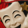 Load image into Gallery viewer, Close-up of a mask with red hair and a gold star on a black background