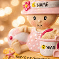 Load image into Gallery viewer, Personalized baby first Christmas ornament for baby girl featuring a beach and summer inspired design. This adorable keepsake includes handwritten name and year personalization, a soft pink baby figure, sand details and playful seaside elements. The ornament has a lightweight 2D base with raised 3D detailing on the front only. Perfect for babyâs first Christmas, nursery decor, coastal holiday themes and meaningful family gifts.