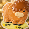 Load image into Gallery viewer, Adorable Highland cow themed Christmas ornament featuring a fluffy brown cow design with soft rounded details and a warm countryside feel. Styled in a natural green meadow setting, this ornament is designed to be personalized and brings a cozy farm inspired charm to holiday tree decor.
