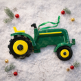 Load image into Gallery viewer, Green tractor ornament featuring a classic farm tractor design with a deep green glossy finish and yellow wheel details. The ornament includes free handwritten personalization with one name and one year, making it a meaningful keepsake for farm families and tractor loving children. Inspired by country life and rural traditions, this ornament is perfect for farmhouse Christmas decor and personalized holiday displays.