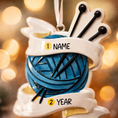 Load image into Gallery viewer, A cozy knitting yarn ornament featuring a detailed blue ball of yarn wrapped with flowing ribbon and raised knitting needles. The ornament has a sculpted 3D front with realistic yarn texture and smooth glossy finish, while the back is flat and 2D for easy hanging. Personalized with a handwritten name and year, this resin ornament is displayed in a warm festive setting with soft holiday lights, creating a heartfelt and nostalgic feel. Perfect for grandmother gifts, knitting lovers, and handmade craft themed