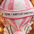 Load image into Gallery viewer, Personalized baby first Christmas ornament featuring a soft pastel pink hot air balloon design with a sweet baby character inside the basket. Handwritten baby name and year or Baby’s First Christmas text displayed on the balloon. Smooth resin finish with gentle glitter accents, nursery themed colors, lightweight structure, mostly 2D ornament with raised 3D details on the front only, designed for baby Christmas tree decor and keepsake gifting.