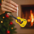 Load image into Gallery viewer, Personalized guitar ornament featuring a classic acoustic guitar design with detailed strings and wood texture. Custom name and year handwritten directly on the guitar body. High detail 3D resin ornament with white hanging ribbon. Perfect Christmas tree decoration for guitar players musicians music lovers and acoustic guitar fans. Warm musical theme ideal for holiday decor and meaningful personalized gifts.