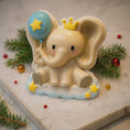 Load image into Gallery viewer, Decorative elephant figurine with a crown and balloon, surrounded by Christmas decorations on a light surface.