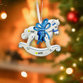 Load image into Gallery viewer, Decorative rocking horse ornament with a blue bow on a blurred Christmas tree background.