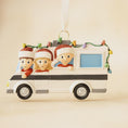 Load image into Gallery viewer, Decorative Christmas ornament shaped like a camper with three animated characters inside on a beige background.