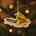 Load image into Gallery viewer, Yellow snowmobile ornament hanging on a Christmas tree with blurred lights in the background