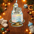 Load image into Gallery viewer, Decorative ornament with baby shower theme featuring an elephant and text on a wooden surface with Christmas decorations.