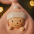 Load image into Gallery viewer, Decorative item shaped like a baby with a smiling face, held in a mouth.