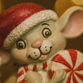 Load image into Gallery viewer, Decorative mouse figurine wearing a Santa hat and holding a peppermint candy.