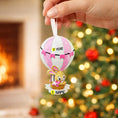 Load image into Gallery viewer, A personalized baby girl ornament featuring a cute bunny riding a pastel pink hot air balloon. Soft pink and white tones with delicate bow details create a sweet and cozy look. Handwritten personalization includes baby name and year. Mostly 2D ornament with raised 3D details on the front only, lightweight and easy to hang, perfect for baby first Christmas, nursery decor, and toddler keepsakes.