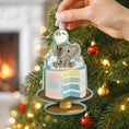 Load image into Gallery viewer, Decorative ornament with a baby elephant on a cake, held over a Christmas tree.