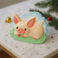 Load image into Gallery viewer, Decorative pig ornament on a marble surface with Christmas decorations in the background