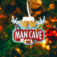 Load image into Gallery viewer, Man cave themed personalized ornament featuring a bold red Man Cave sign design with raised 3D details including beer mugs antlers sports icons and hobby elements. The ornament allows name personalization on the top area and year personalization at the bottom making it a fun and meaningful keepsake. Designed with a flat back for easy hanging this ornament is perfect for man cave decor Christmas trees or gift displays. Ideal for dads husbands boyfriends and anyone who loves their personal space traditions an