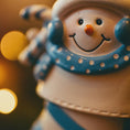 Load image into Gallery viewer, Close-up of a snowman figurine with a blue scarf against a blurred light background