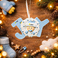 Load image into Gallery viewer, Decorative ornament with baby design on a wooden surface with Christmas decorations.