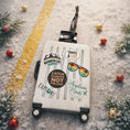 Load image into Gallery viewer, Travel-themed suitcase with decorative elements on a snowy ground with Christmas decorations.