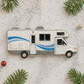 Load image into Gallery viewer, RV-shaped Christmas ornament on a snowy background with pine branches.