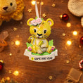 Load image into Gallery viewer, Personalized baby lion Christmas ornament featuring a sweet yellow lion cub wearing a floral crown and holding a small leaf. The bottom banner can be customized with name and year, creating a unique keepsake for a newborn or toddler. Designed in warm yellow and soft pastel tones, this resin baby Christmas ornament is perfect for celebrating Baby’s First Christmas or adding a personalized jungle themed touch to your holiday tree.