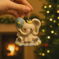 Load image into Gallery viewer, Decorative elephant ornament with a balloon and crown, held by a hand against a festive background.