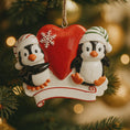 Load image into Gallery viewer, Christmas ornament with two penguins and a red heart on a tree.