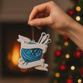 Load image into Gallery viewer, A cozy knitting yarn ornament featuring a detailed blue ball of yarn wrapped with flowing ribbon and raised knitting needles. The ornament has a sculpted 3D front with realistic yarn texture and smooth glossy finish, while the back is flat and 2D for easy hanging. Personalized with a handwritten name and year, this resin ornament is displayed in a warm festive setting with soft holiday lights, creating a heartfelt and nostalgic feel. Perfect for grandmother gifts, knitting lovers, and handmade craft themed