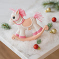 Load image into Gallery viewer, Decorative rocking horse with pink mane on a snowy surface with Christmas ornaments.