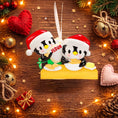 Load image into Gallery viewer, Cute penguin couple ornament featuring two festive penguins baking together, dressed in Santa hats and sharing a cozy holiday moment. This playful Christmas ornament is perfect for couples, partners, siblings, or loved ones who enjoy cooking, baking, or spending time together during the holidays. A charming keepsake that adds warmth, fun, and personality to any Christmas tree or seasonal decor.