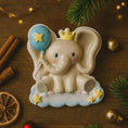 Load image into Gallery viewer, Decorative elephant figurine with a blue balloon and yellow stars on a wooden surface with cinnamon sticks and pine branches.