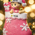 Load image into Gallery viewer, Personalized Baby Girl Christmas Ornament featuring a sweet baby in a pink stocking with raised 3D front details and textured snowflake accents. The name is added on the hat and the year on the stocking, creating a meaningful newborn keepsake. Soft pink tones, holiday elements, and dimensional design make it perfect for babyâs first Christmas, baby girl gift, and special family memory ornament for the tree.
