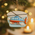 Load image into Gallery viewer, Decorative helicopter ornament hanging on a Christmas tree with blurred lights in the background.