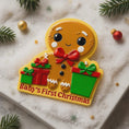 Load image into Gallery viewer, Gingerbread man ornament with 'Baby's First Christmas' text on a decorative surface with Christmas decorations.