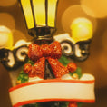 Load image into Gallery viewer, Decorative Christmas ornament with a red bow and festive design on a blurred background