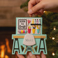 Load image into Gallery viewer, Born to Craft ornament featuring a creative desk scene with colorful craft supplies including scissors paint bottles brushes pencils and storage cups. The ornament showcases a playful crafting workspace design with a modern chair and desk setup. Made from durable resin with a detailed 3D front and flat 2D back for smooth hanging. Includes free handwritten personalization making it a perfect gift for crafters artists DIY lovers and creative kids. Ideal for Christmas trees craft rooms studios and handmade the