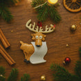 Load image into Gallery viewer, Decorative reindeer ornament on a wooden surface with Christmas decorations.