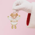 Load image into Gallery viewer, Decorative angel ornament held by a gloved hand on a pink background