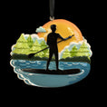 Load image into Gallery viewer, Decorative ornament with a silhouette of a person paddleboarding on water, surrounded by trees and a sunset.