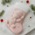 Load image into Gallery viewer, Pink bath bomb with bear ornament design on a snowy background with Christmas decorations