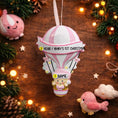 Load image into Gallery viewer, Personalized baby first Christmas ornament featuring a soft pastel pink hot air balloon design with a sweet baby character inside the basket. Handwritten baby name and year or Baby’s First Christmas text displayed on the balloon. Smooth resin finish with gentle glitter accents, nursery themed colors, lightweight structure, mostly 2D ornament with raised 3D details on the front only, designed for baby Christmas tree decor and keepsake gifting.