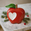 Load image into Gallery viewer, Decorative red apple with a heart cutout on a marble surface with Christmas decorations.