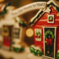 Load image into Gallery viewer, Decorative Christmas house ornament with wreaths and text on a blurred background