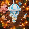 Load image into Gallery viewer, Personalized Baby Boy First Christmas Ornament designed as a charming 3D hot air balloon with a sweet baby in the basket below. The name is featured on the lower section and the year or Baby’s First Christmas message appears on the banner across the balloon. Soft blue and white tones, glitter accents, and raised dimensional details create a playful keepsake. Perfect for newborn boys, baby shower gifts, and celebrating a baby’s first holiday season.