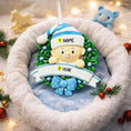 Load image into Gallery viewer, Personalized Baby Boy Christmas Ornament featuring a sweet child peeking from a festive green wreath with blue accents and polka dot bow. This ornament has a raised 3D front design with detailed holly leaves, textured elements, and dimensional lettering. The name is placed on the hat and the year on the banner. A meaningful keepsake for babyâs first Christmas, newborn gift, or holiday memory decoration for the Christmas tree.