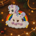 Load image into Gallery viewer, Unicorn ornament with rainbow on a wooden surface with festive decorations