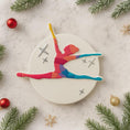 Load image into Gallery viewer, Colorful ceramic ornament of a dancer on a textured surface with Christmas decorations.