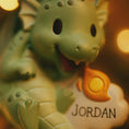 Load image into Gallery viewer, green dragon ornament designed with a fully sculpted 3D front that showcases raised details and expressive features, paired with a smooth 2D flat back for lightweight hanging. The glossy finish enhances the depth of the front design while keeping the back clean and minimal. Personalized name and year placement are clearly visible, making this dragon ornament a magical keepsake and a charming addition to holiday decor or fantasy themed collections.